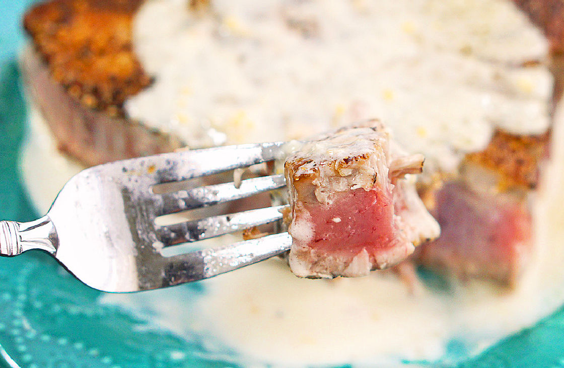a fork with a bit of the fish with the cream sauce
