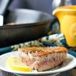 white plate with seared tuna steaks with lemon dijon sauce, lemons and text