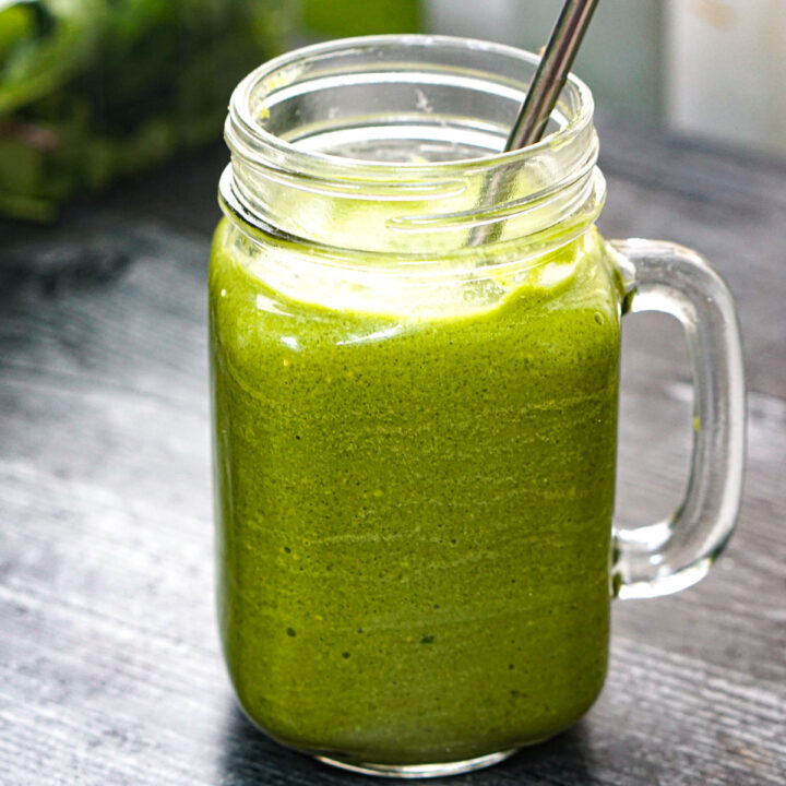 Closuep of jar of low carb vanilla mint matcha smoothie with a silver straw.