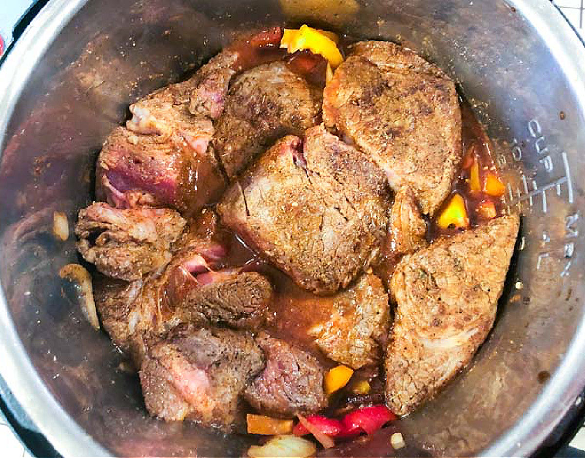 Closeup of the pressure cooker with all the ingredients in ready to cook.