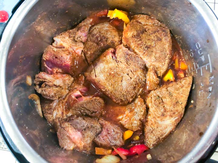 barbacoa beef chunks and peppers in the instant pot ready to cook