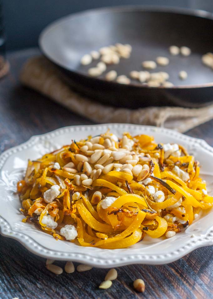  golden beet noodles on white plate with pan in background