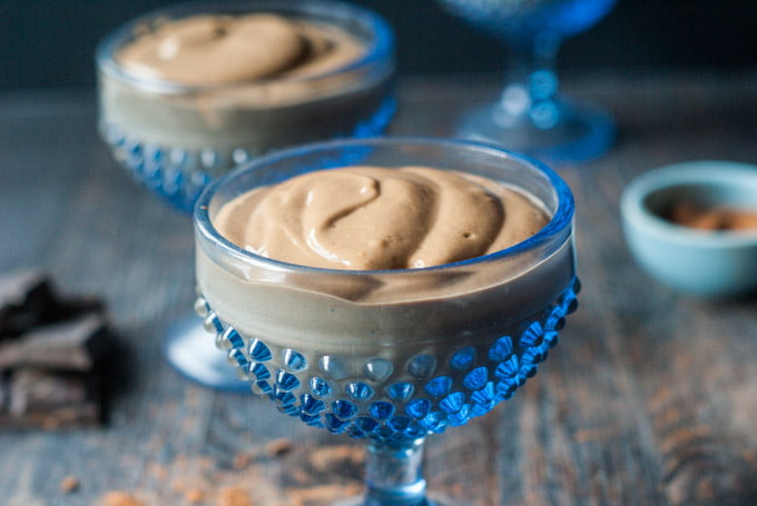 two blue dessert cups with keto chocolate peanut butter protein pudding