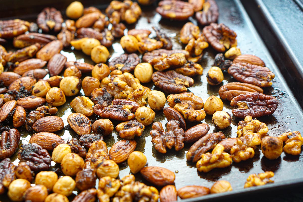Closeup of a sheet pan with the drying spiced nuts.