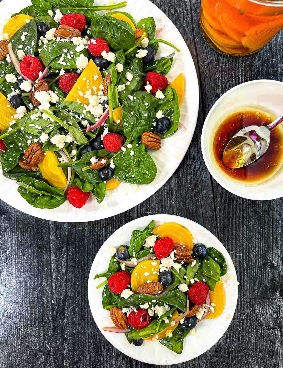 Pickled Beet & Gorgonzola Spinach Salad - bright, beautiful, delicious and nutritious! Aerial view of plates of pickled beet salad with berries and a bowl of dressing.