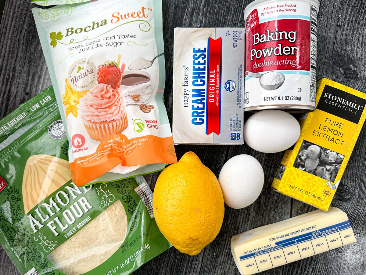 recipe ingredients - cream cheese, almond flour sweetener, baking powder, lemon extract, eggs, butter and lemon