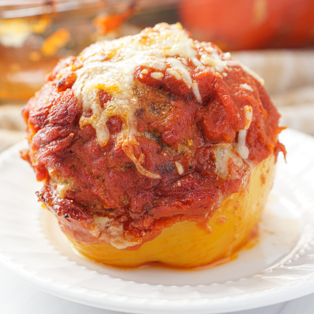 white plate with a cheesy meatball stuffed peppers