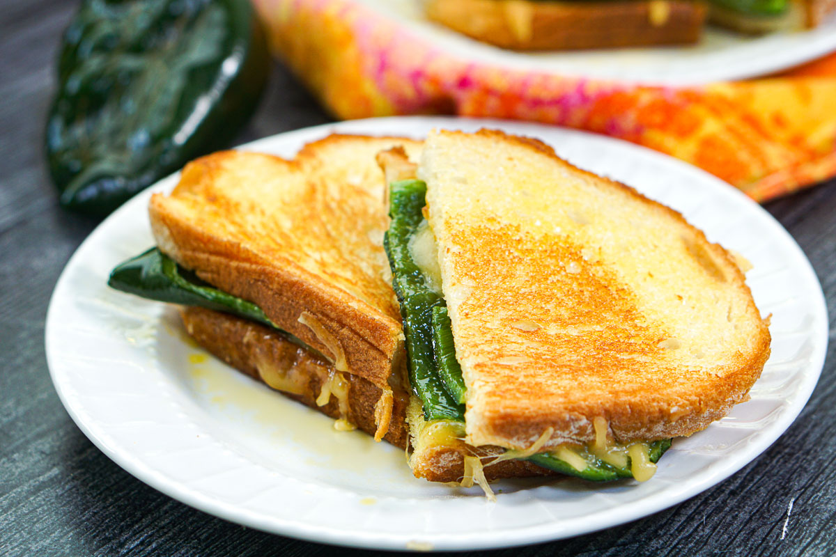 white plate with two halves of a poblano grilled cheese sandwich