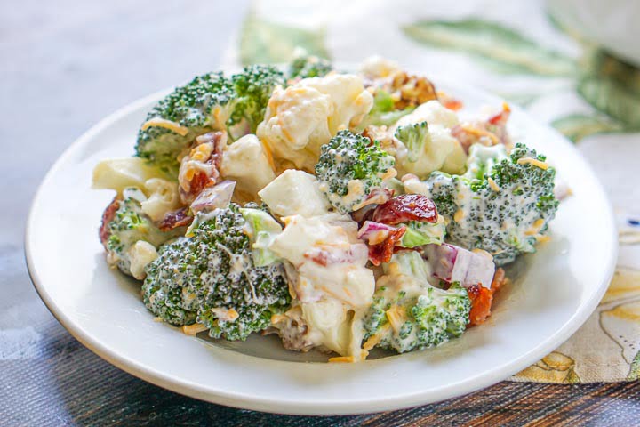 white plate with loaded low carb broccoli cauliflower salad 