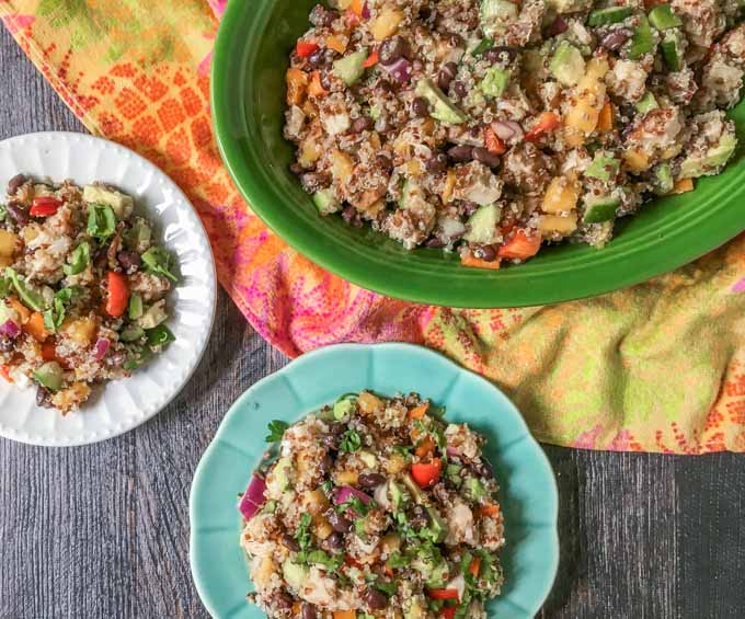 This Caribbean chicken quinoa salad is perfect for a summer dinner or picnic. Full of colorful fruit and vegetables and topped with spicy jerk chicken and chewy quinoa.