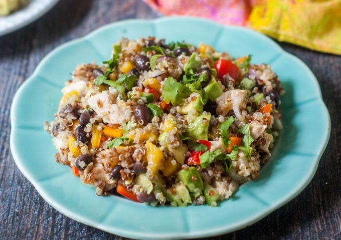 This Caribbean chicken quinoa salad is perfect for a summer dinner or picnic. Full of colorful fruit and vegetables and topped with spicy jerk chicken and chewy quinoa.
