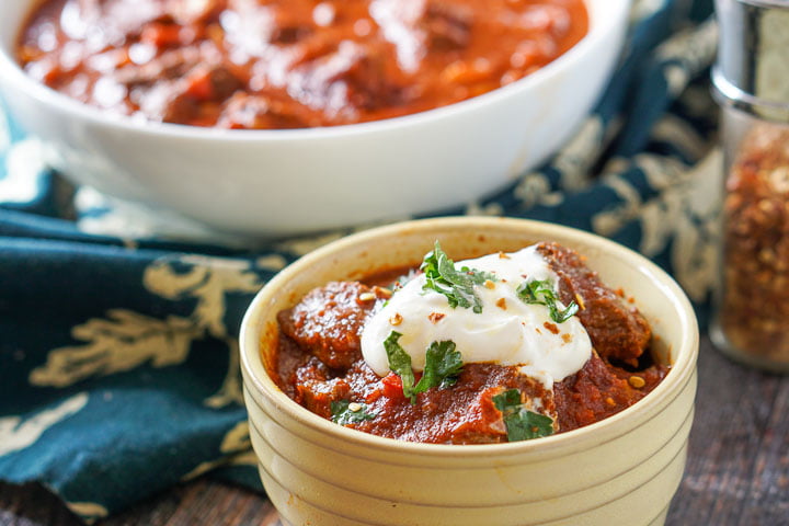 yellow bowl with chunky beef chili without beans with white bowl in background