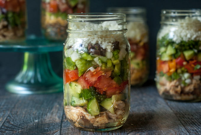 Greek chicken salad in a jar with other jars in the background