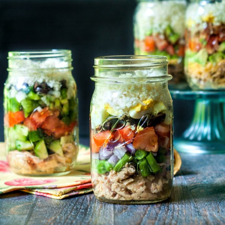 mason jars filled with low carb cauliflower rice salads in different flavors