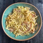 Aerial view of a aqua bowl with the radish and cabbage curried coleslaw.