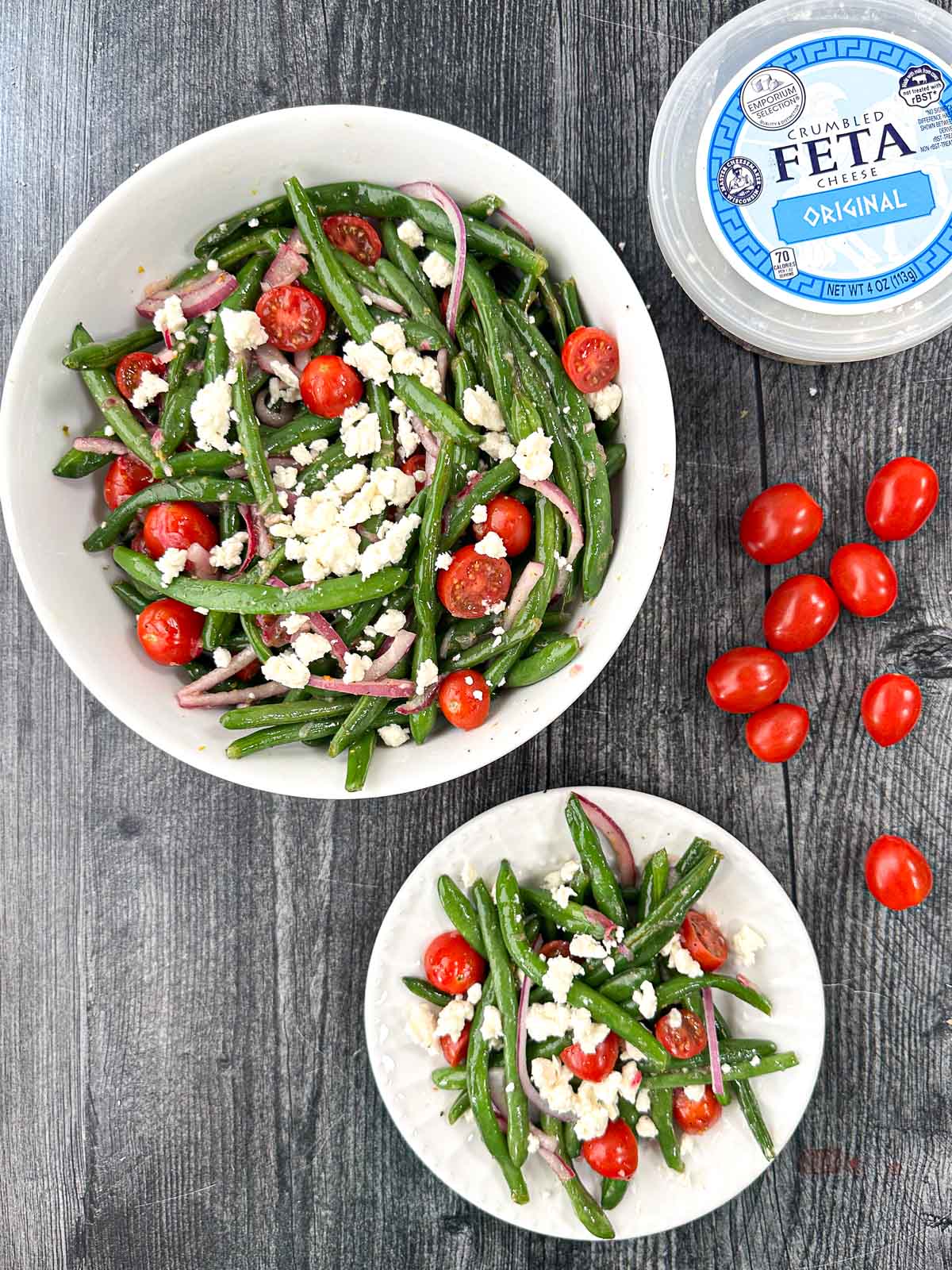 aerial bowl and plate with Greek green bean salad recipe and fresh grape tomatoes and a container of feta cheese