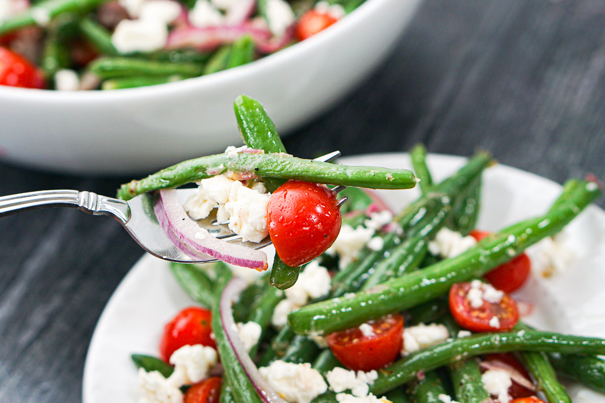 a forkful of beans, tomatoes and feta