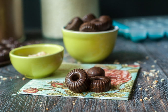  low carb toasted coconut chocolate candy on floral napkin with green bowl in background