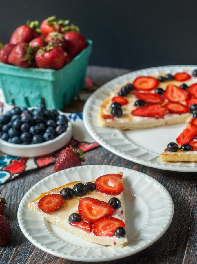fathead fruit pizza with strawberries and blueberries on white plates 