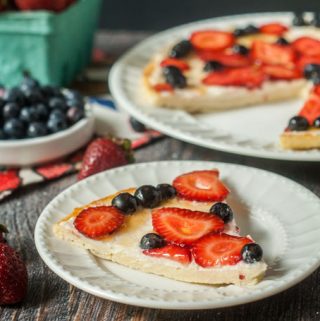fathead fruit pizza with strawberries and blueberries on white plates
