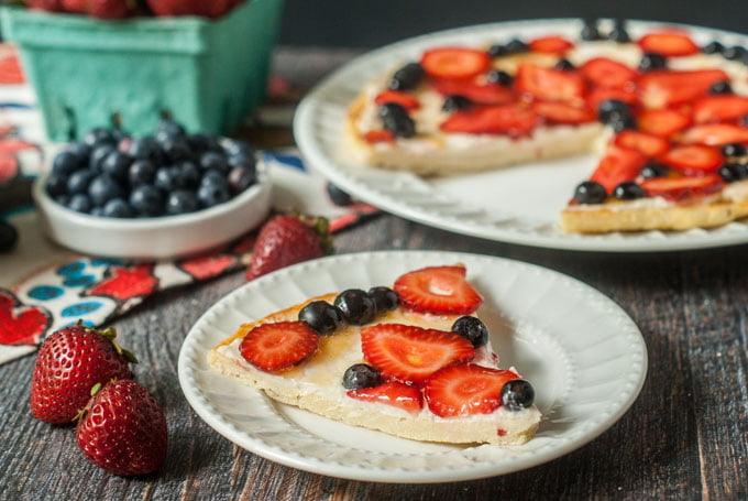 fathead fruit pizza with strawberries and blueberries on white plates 