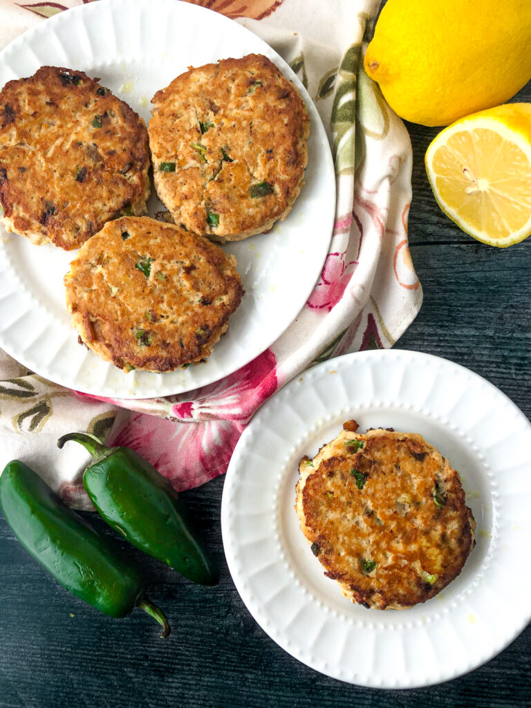 aerial view of salmon cakes and fresh lemon and jalapenos
