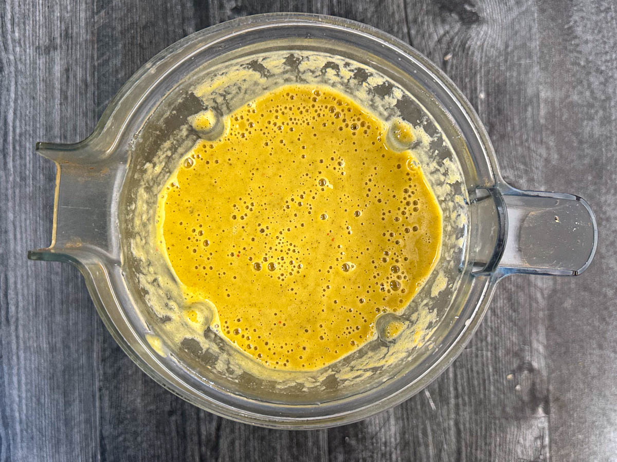 Blender pitcher with the blended zucchini soup.