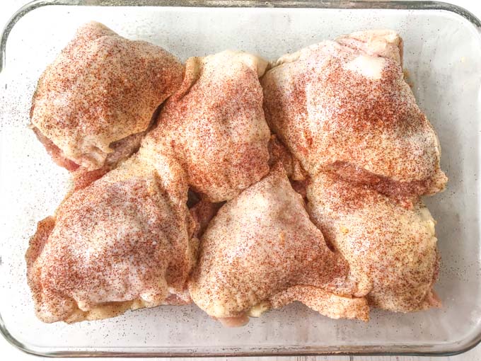 raw chicken thighs stuffed with paprika sprinkled on top