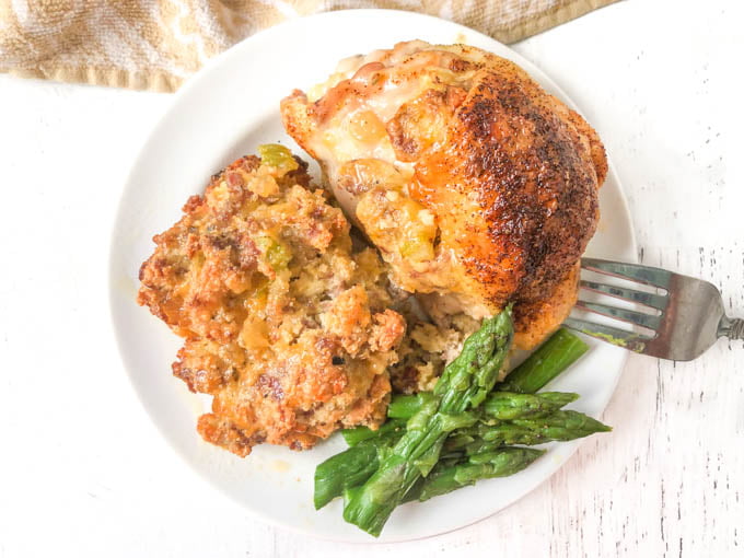 white plate with keto stuffing, chicken thigh and asparagus 