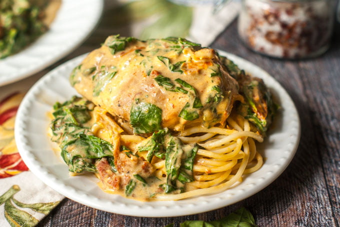 This slow cooker creamy tomato chicken & spinach dish is full of flavor and easy for a weeknight dinner. The rich and creamy sauce is perfect with the fresh spinach and chicken and only 3.3g net carbs!