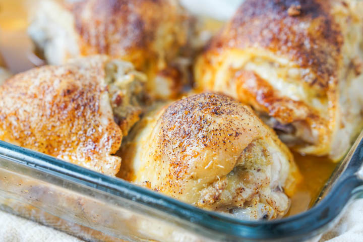 closeup of stuffed chicken thighs in baking dish