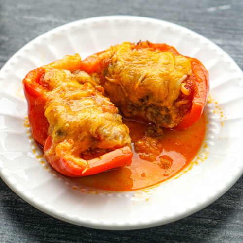 closeup of a white plate with a chorizo stuffed bell pepper cut in half