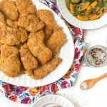 white platter with keto fried pork cutlets with floral cloth and text overlay