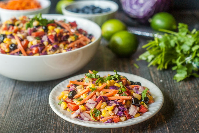 This rainbow Mexican corn salad is a tasty twist on Mexican corn. Colorful vegetables and fruit are tossed in a creamy lime dressing for the perfect sweet and tangy salad. A beautiful and tasty side dish for picnics and parties.