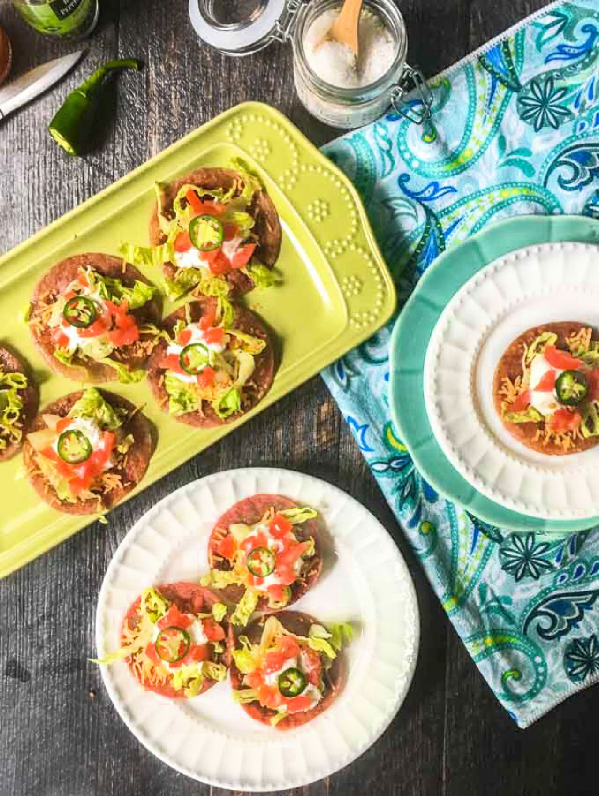 Low Carb Salami Tostadas - only 5 minutes to make and 0.6g net carbs per serving! A tasty, low carb appetizer too! Aerial view of a plates and platters of the salami tostadas.
