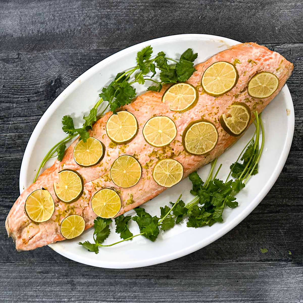 White platter with margarita salmon and parsley sprigs.