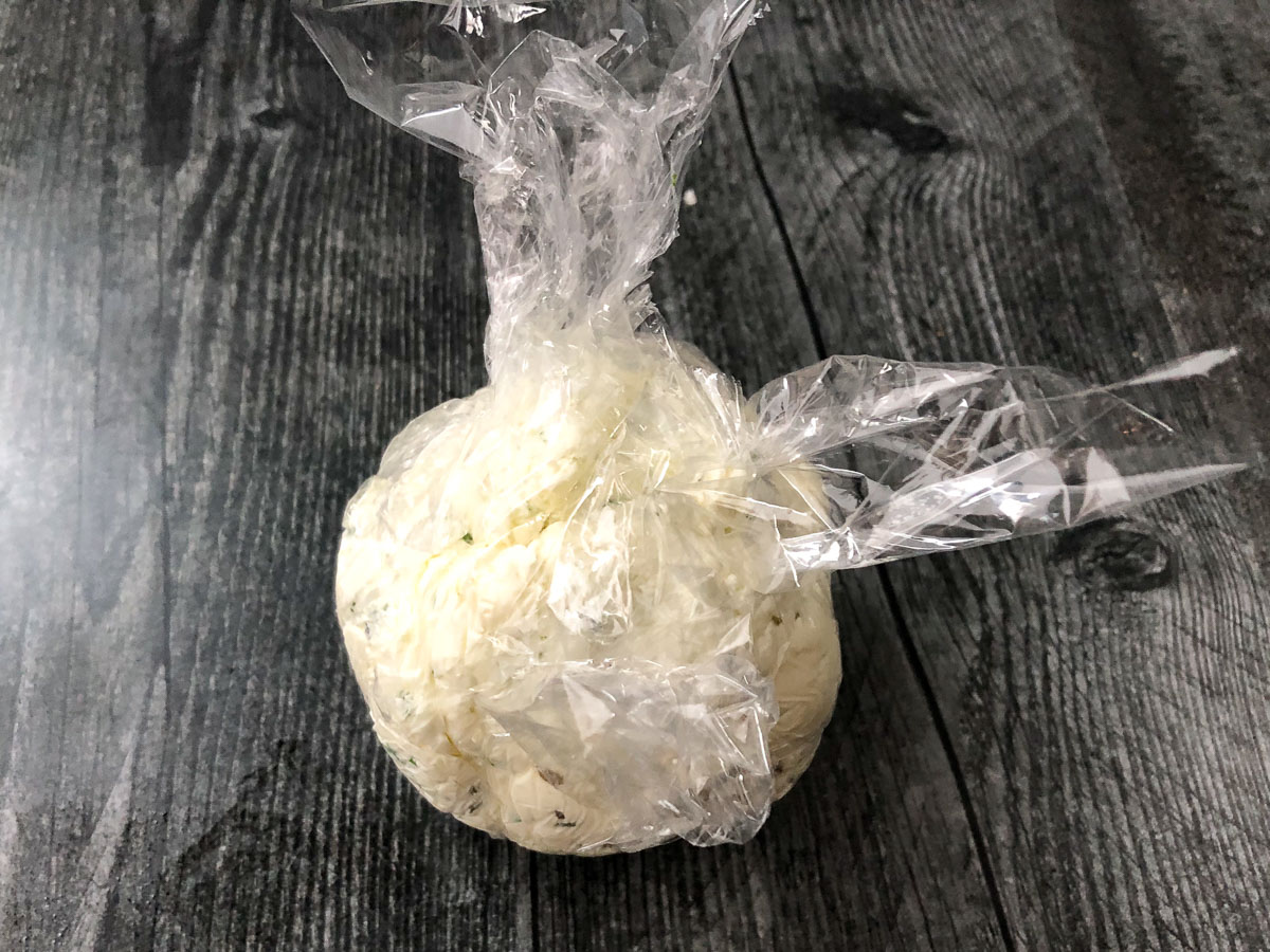plastic wrap covering the round cheeseball