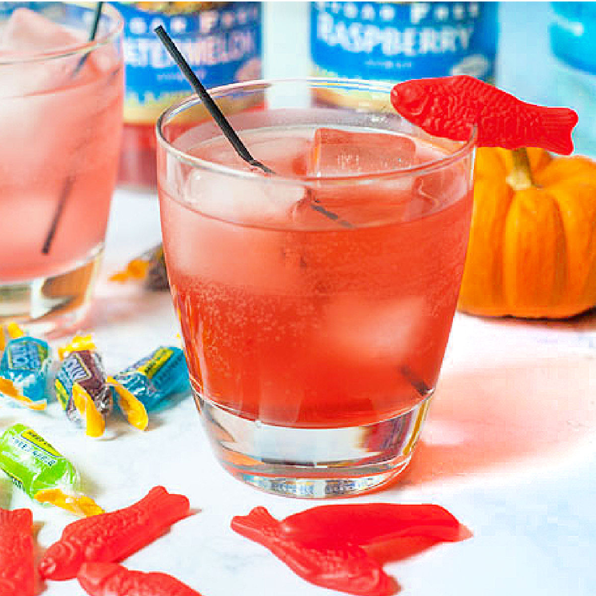 Swedish fish keto Halloween candy drinks with scattered candy Swedish fish and bottles in the background