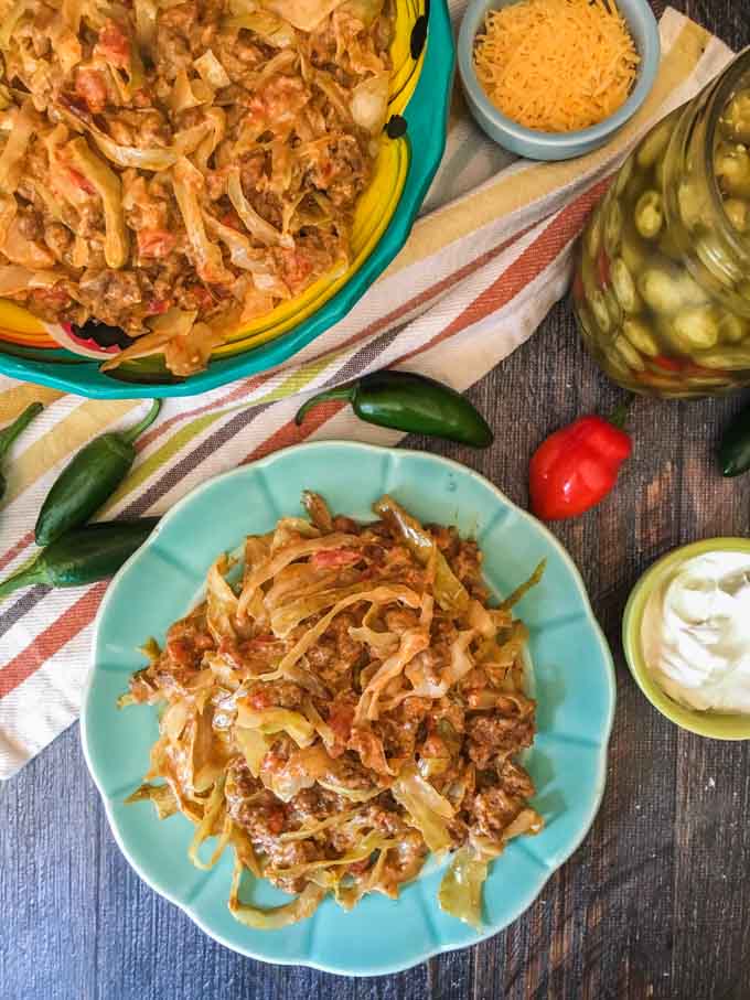 green plate and colorful bowl of Mexican casserole and jalapeños 