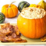 pumpkin filled with keto pumpkin cheesecake dip with bacon chips and text overlay