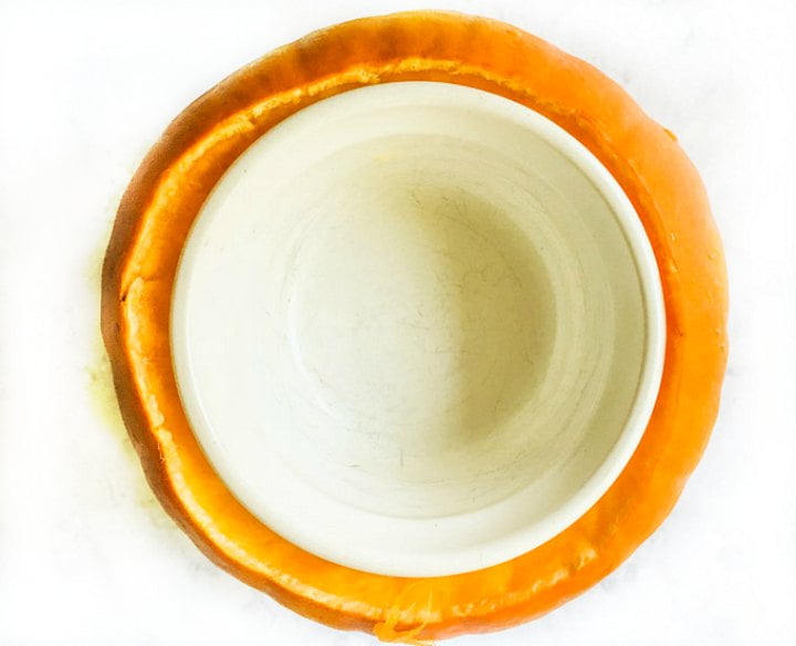 aerial view of a cleaned out pumpkin with a white ramekin in the middle