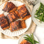large and small white plates with Asian glazed salmon with green beans and text