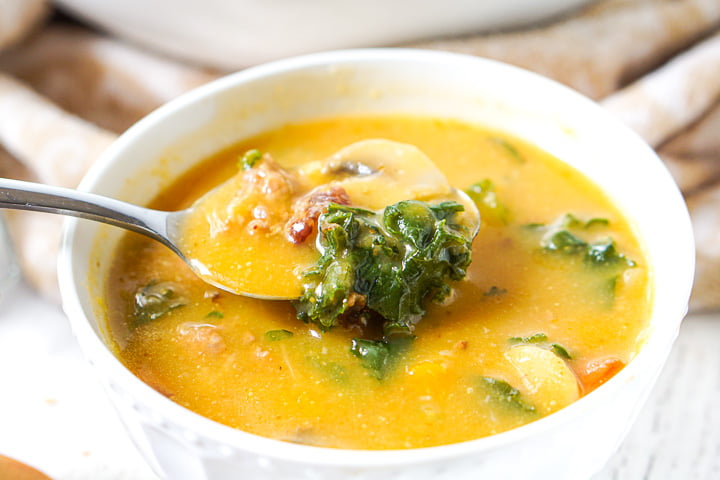 spoonful of soup with mushrooms and kale
