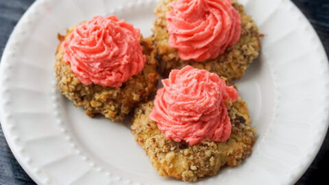 3 thumbprint cookies with icing on a white plate