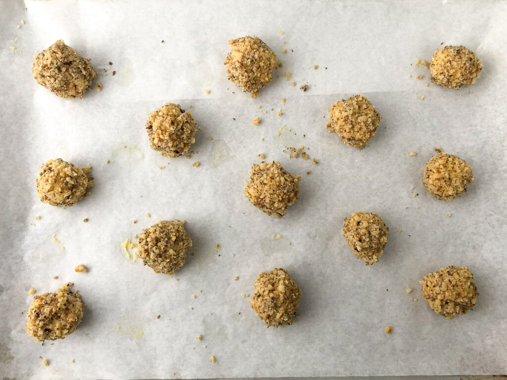 cookie dough balls on a parchment covered baking sheet