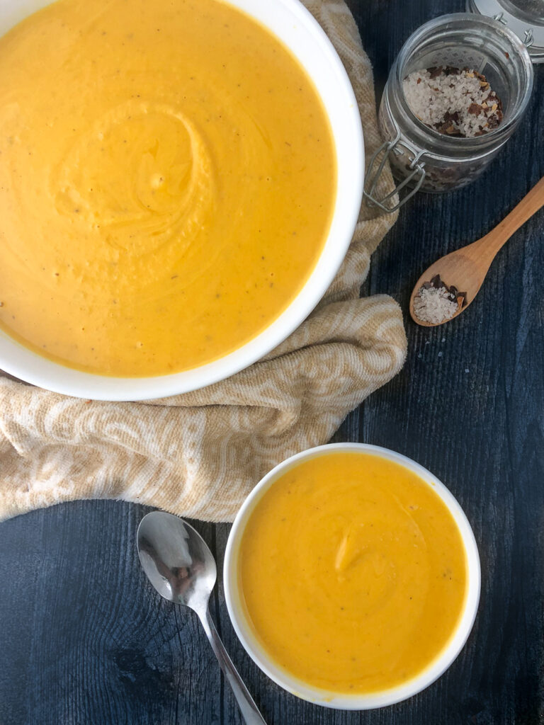 large and small bowls of squash soup 
