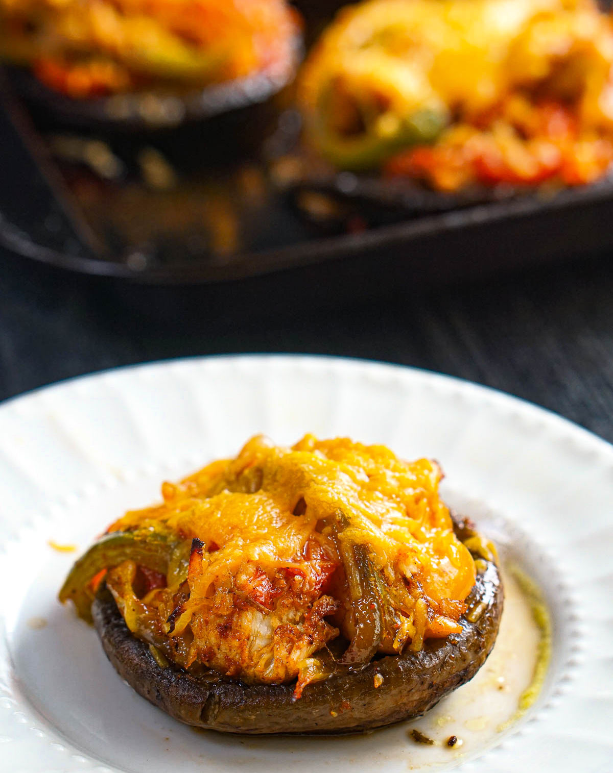These fajita stuffed portobellos make for a delicious and easy low carb dinner. White plate with a stuffed portobello mushroom with chicken fajitas.