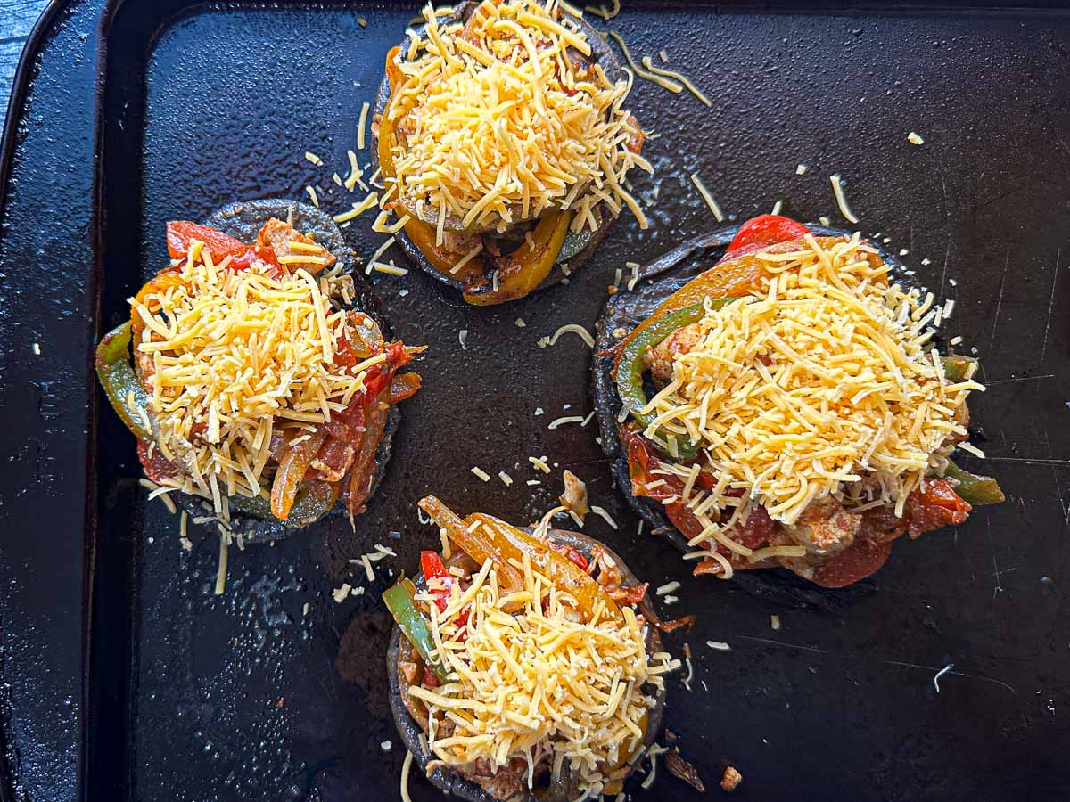 Baking sheet with stuffed mushroom caps ready to bake.