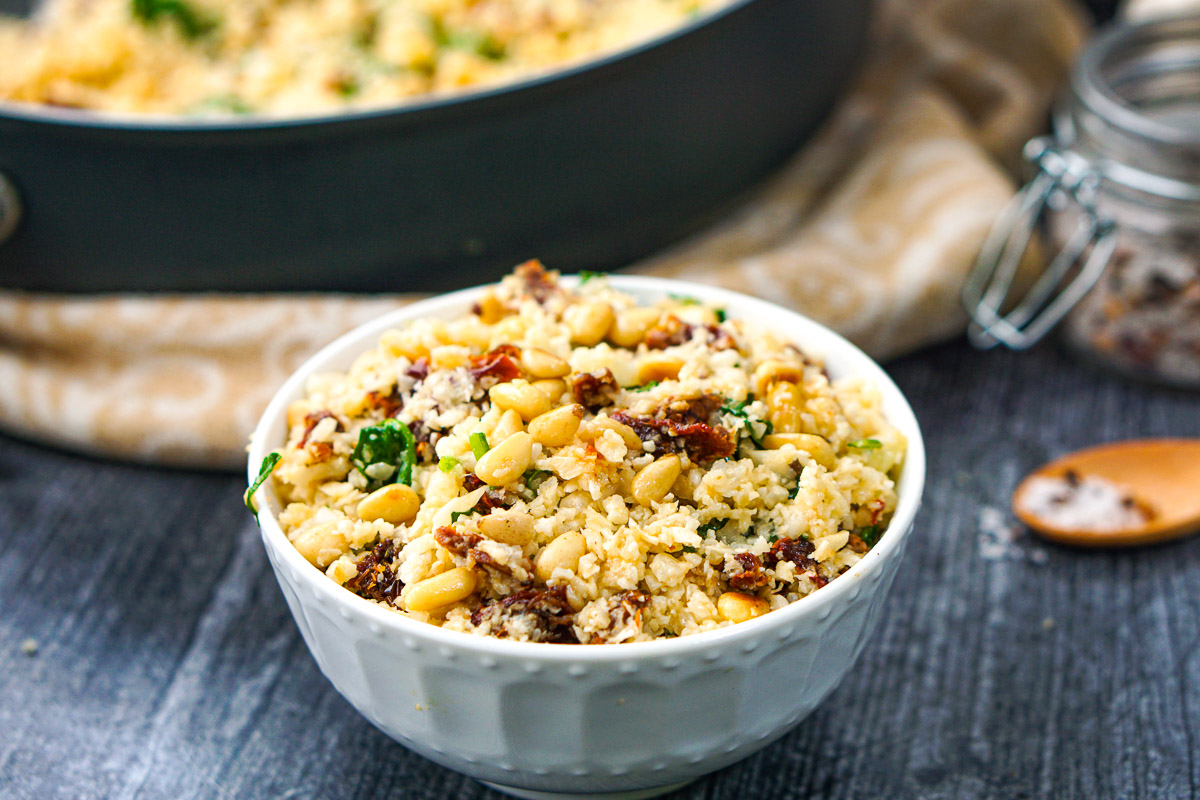 white bowl with finished sun-dried tomato and spinach cauliflower rice