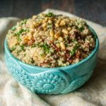 This festive tomato and spinach cauliflower rice only takes 15 minutes to make and is a delicious low carb side dish. Cauliflower rice takes on the flavors sun dried tomatoes and garlic and is topped with crunchy pine nuts.  #cauliflowerrice #lowcarbsidedish #cauliflower #lowcarb